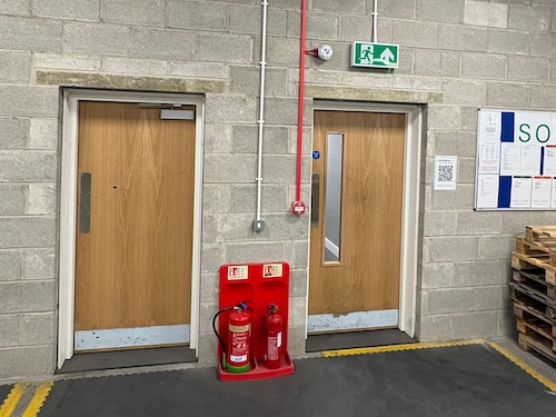 Fire alarm call point positioned at emergency exit at PackagingOne Middlewich warehouse